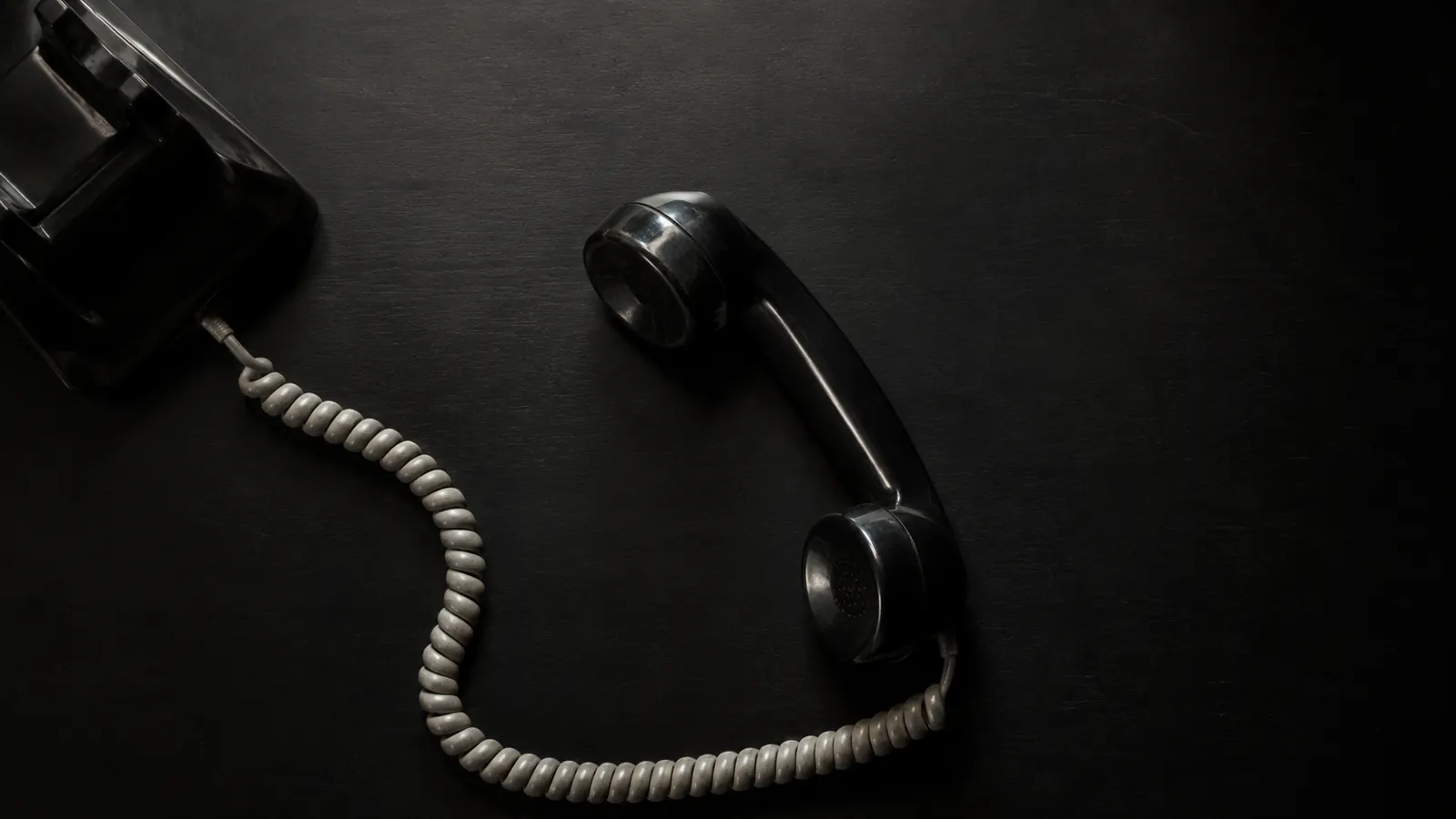 A desk telephone handset resting off the hook